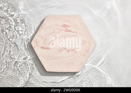 Empty marble podium on transparent clear white calm water texture with splashes and waves in sunlight for product advertising Stock Photo