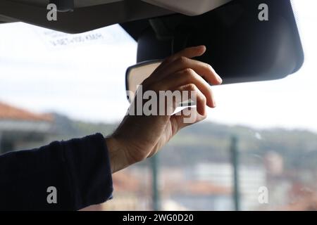 Man driving car with hands on side mirror Stock Photo