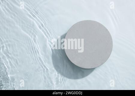 A gray circle podium isolated on the water surface background. Product promotion. Beauty cosmetic showcase. Stock Photo