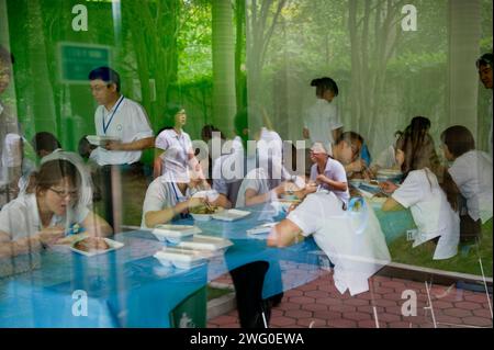 Factory workers taking a lunch in a canteen within the factory's premises. Stock Photo