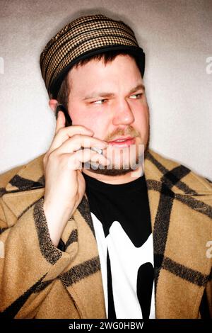 Young hip man talks on his cell phone looking away. Stock Photo