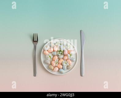 Pastel easter Eggs on Plate with Utensils. easter concept Stock Photo