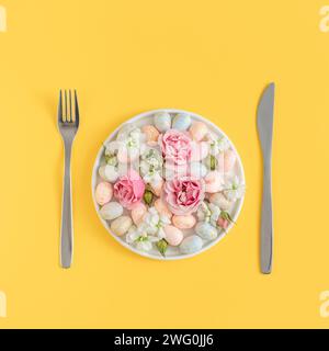 easter dining concept with speckled eggs and  flowers on a white plate Stock Photo