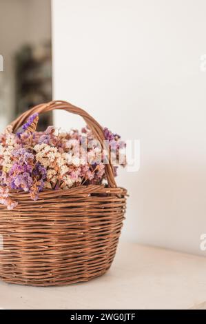 Colorful dried floral arrangement in woven basket on white background Stock Photo