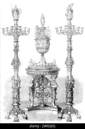 The International Exhibition: vase and candelabra presented to their Royal Highnesses Crown Prince and Princess of Prussia by the City of Berlin, 1862. A '...wedding-gift...[which consists of] four pieces, in solid silver. The designer and modeller is Professor Auguste Fischer, and the work has been executed by him in conjunction with other eminent artists. The table reproduces very perfectly the form of the ancient tripod. It is three feet in height. Three lions' paws, ornamented with foliage, support the centre, around which are three sitting figures of Faith, Love, and Hope, whoso meeting w Stock Photo