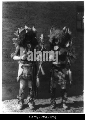 Tesuque buffalo dancers, c1927. Two Native American men in costumes wearing horns of buffaloes. Stock Photo