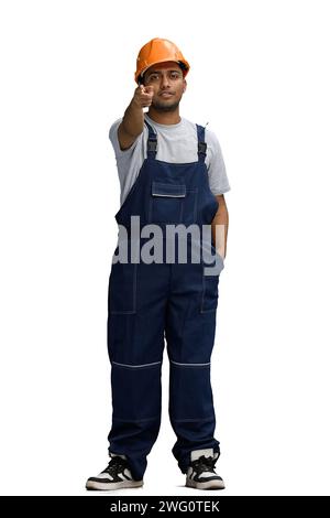 a man in a construction uniform on a white background points full-length ahead Stock Photo