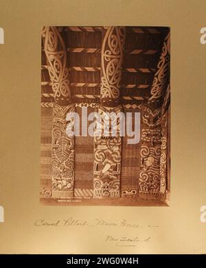 carve Pillars Maori house.  New Zealand Interior of Maori house showing three elaborately carved wooden pillars. Each pillar has a representation of a fierce-looking figure with protruding tongue. Two have short, wooden paddles in their hands, possibly a symbol of authority. From Charles Appleton Longfellow's trip to New Zealand in 1891. Stock Photo