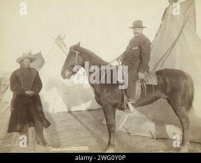 Chief Rocky Bear's home, 1891. Rocky Bear, Oglala chief, standing to the left of a Euro-American man on horseback; three tipis in the background--probably on or near Pine Ridge Reservation. Stock Photo