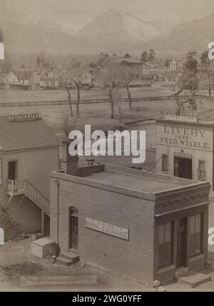 Colorado, 1888. Showing three buildings with signs reading: Grabill's Mining Exchange, Photographs, and El Paso Livery; river and houses in middle-ground; mountains in background. Stock Photo