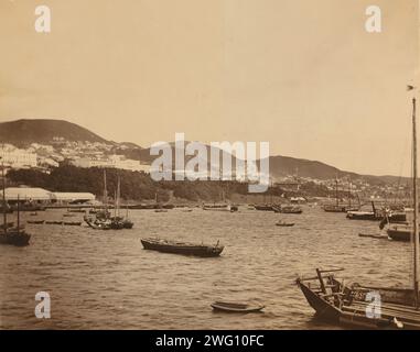 View of Vladivostok, Russia, from the Bay of the Golden Horn, 1899. Showing boats in the harbor. In the distance are market stalls by the shore, the Governor's House above them, the Admiral's Garden stretching along the Bay, the Admiralty (white building with cupola), and the Uspenskii Sobor (Cathedral of the Assumption) in the center. In: Photograph album of Pray family expatriate life in Vladivostok, Russia. Eleanor L. Pray Collection. Stock Photo