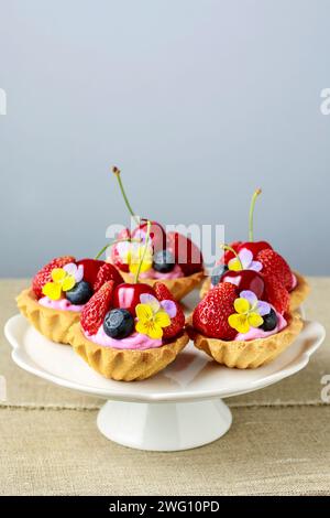 Cupcakes with fresh fruits and edible flowers. Party dessert Stock Photo