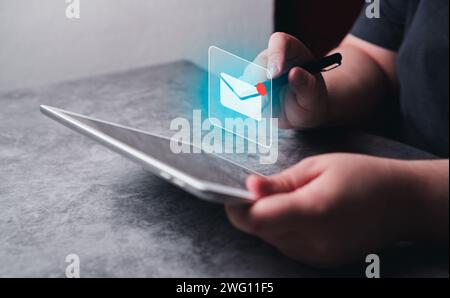 Woman use digital tablet with hologram mail icon interface. Email marketing concept. Send email or newsletter. Stock Photo