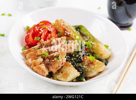 Stir fried of chicken, sweet peppers and bok choy in a bowl on the table. Stir fry pak choi. Asian food. Stock Photo