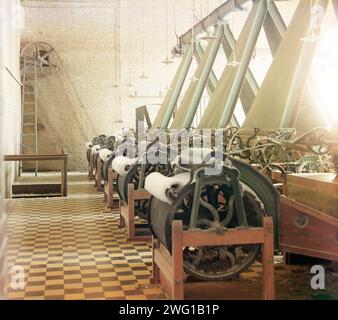 Cotton textile mill interior with machines producing cotton thread, probably in Tashkent, between 1905 and 1915. The location, though unidentified, is most likely in Tashkent which is known for textile production. Because of the warm, dry climate, Central Asia - and particularly Uzbekistan - was an ideal location for growing and processing cotton for the entire Russian empire. Stock Photo