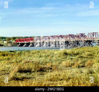 Bridge beyond the rapids, over the Syr-Darya from the right bank, Golodnaia (or Golodnaya) Steppe, between 1905 and 1915. The Syr Darya, a river in Central Asia, originates in the Tian Shan Mountains and flows for 2,256.25 kilometres through Uzbekistan and southern Kazakhstan to the northern remnants of the Aral Sea. Stock Photo