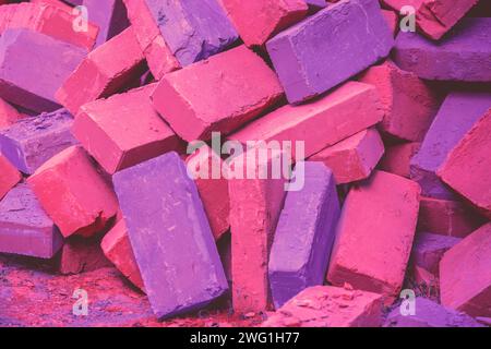 Clay handmade bricks. Abstract pile of bricks background. Bright magenta purple colored Stock Photo