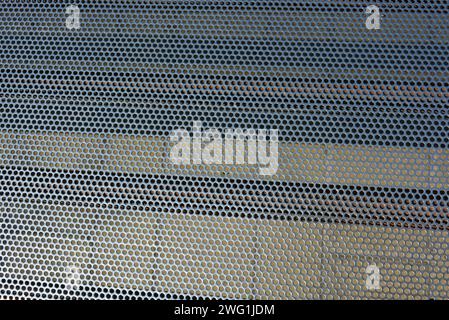 Metal mesh, background, with round identical holes, metal structure with shadow and light. Stock Photo
