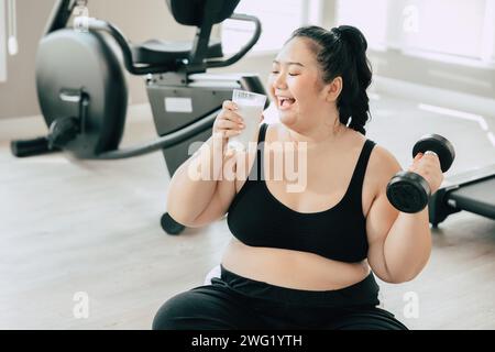 sport healthy fat women happy smiling enjoy drink milk and diet exercise activity in fitness sport club Stock Photo