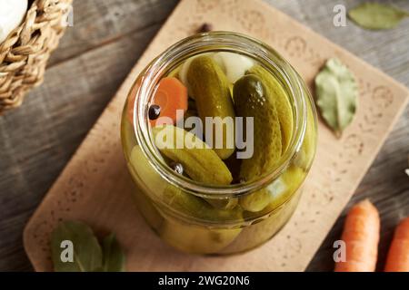 Homemade pickled cucumbers or gherkins in a glass jar on a table, top view Stock Photo
