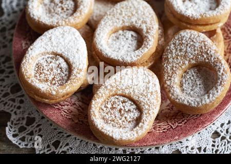 Linzer cookies in the shape of Easter eggs on a red plate, close up Stock Photo