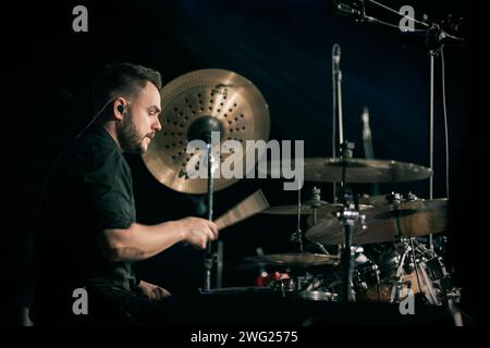 A drummer playing with drumsticks on his instrument at a concert Stock Photo