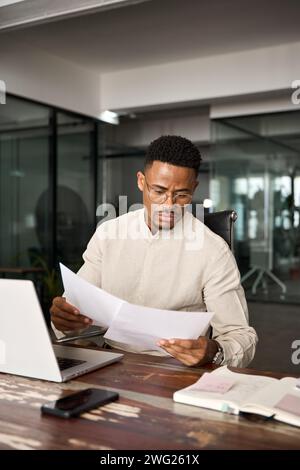 Busy African American lawyer checking documents working at laptop in office. Stock Photo