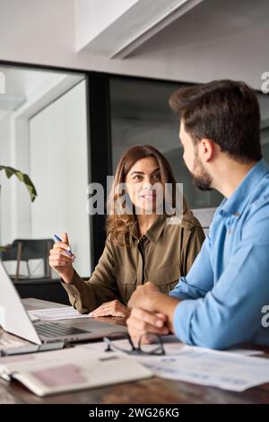 Busy professional business people working in office with laptop and talking. Stock Photo