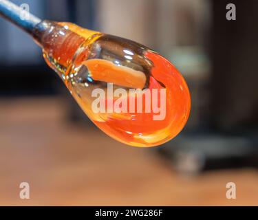 Glassblowing. Molten glass on edge of pontil. Manual process of glass blowing and forming a decorative vase. Stock Photo