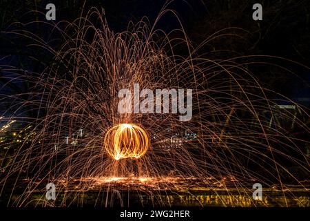 A mesmerizing image capturing the beautiful spectacle of fire spinning with firecrackers near the water Stock Photo