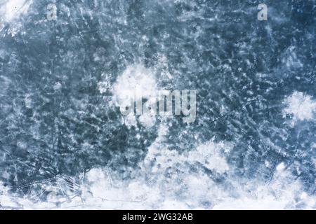 Frozen lake texture background. Water surface covered with ice and snow from aerial view. Stock Photo