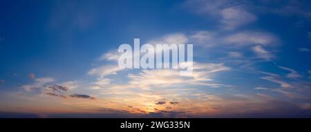 Beautiful sunset sky with clouds. Panorama of dramatic sky during golden hour. Stock Photo