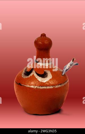 piggy bank made of clay in red background, isolated Stock Photo