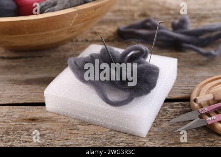 Felting tools and wool on wooden table, closeup Stock Photo
