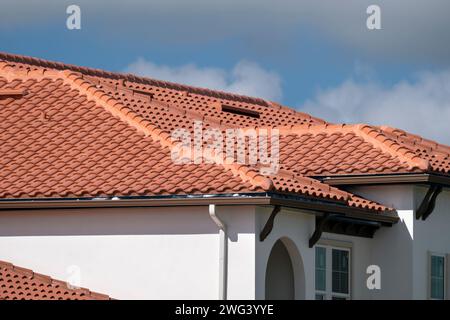 Overlapping rows of yellow ceramic roofing tiles covering residential building roof in southern Florida Stock Photo