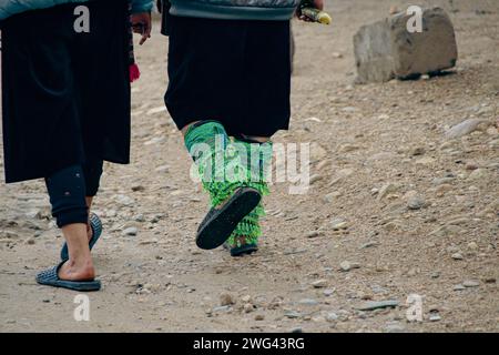 Close up to two black hmong women walking and wearing their ethnic leg ornaments, showing the authentic daily life and culture in Lao Chai Village Sa Stock Photo