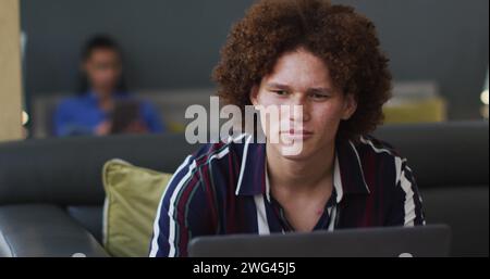 Young biracial man works on a laptop at home Stock Photo