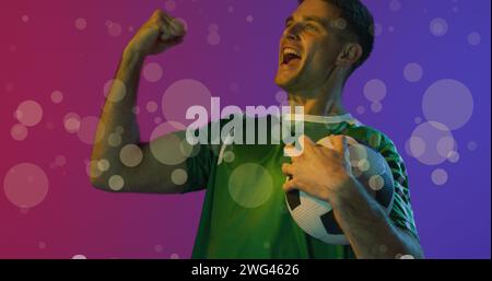 Image of caucasian male soccer player over spots Stock Photo