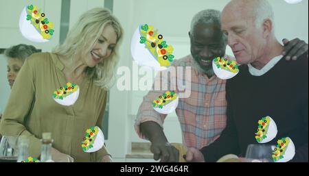 Image of salad icons over diverse group of seniors cooking Stock Photo