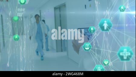 Image of network of digital icons over male doctor using tablet Stock Photo