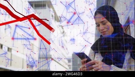Red graphs moving and network of connections against woman in hijab using smartphone Stock Photo