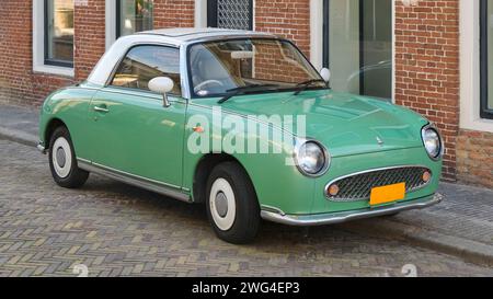 A light green Nissan Figaro in a street in the Netherlands. Only 12000 Nissan Figaro's were produced in Japan. Stock Photo