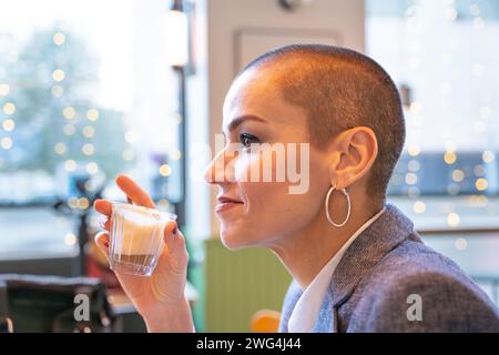 Side view stylish smiling woman drinking coffee in cafe Stock Photo
