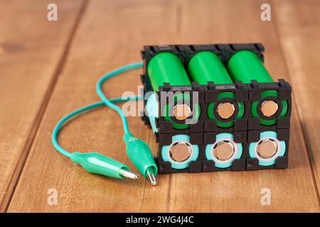 Lithium battery pack in black plastic holder wooden table. Stock Photo