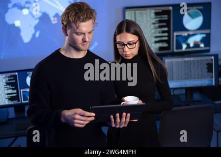 Two professionals in cyber security team working to prevent security threats, find vulnerability and solve incidents Stock Photo