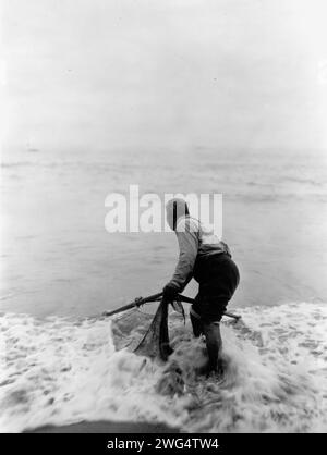 The smelt fisher-Trinidad Yurok, c1923. Photograph shows a Yurok man fishing with a net, probably in the Trinidad area of California. Stock Photo