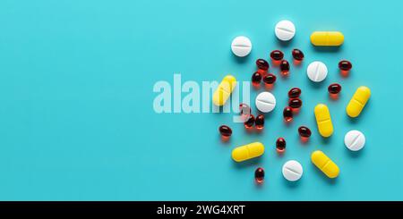 Colorful medical pills on blue background, assorted tablets close-up, top view. Heap of different dietary supplements. Beautiful pattern, empty place Stock Photo