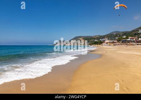 Sunny Kleopatra Beach in Alanya, Turkey, with paragliders soaring above ...