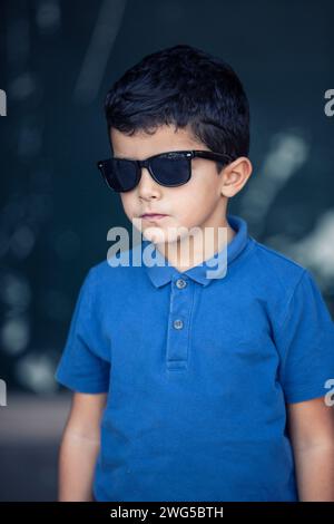 6 years old middle eastern boy wearing sunglasses outdoors Stock Photo