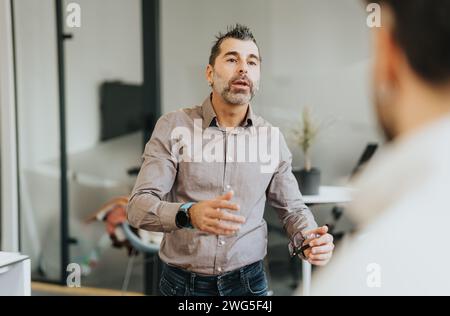 Different aged colleagues discussing ideas for business growth in an meeting. Stock Photo